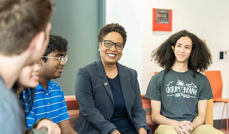 Harriet sits talking with students.